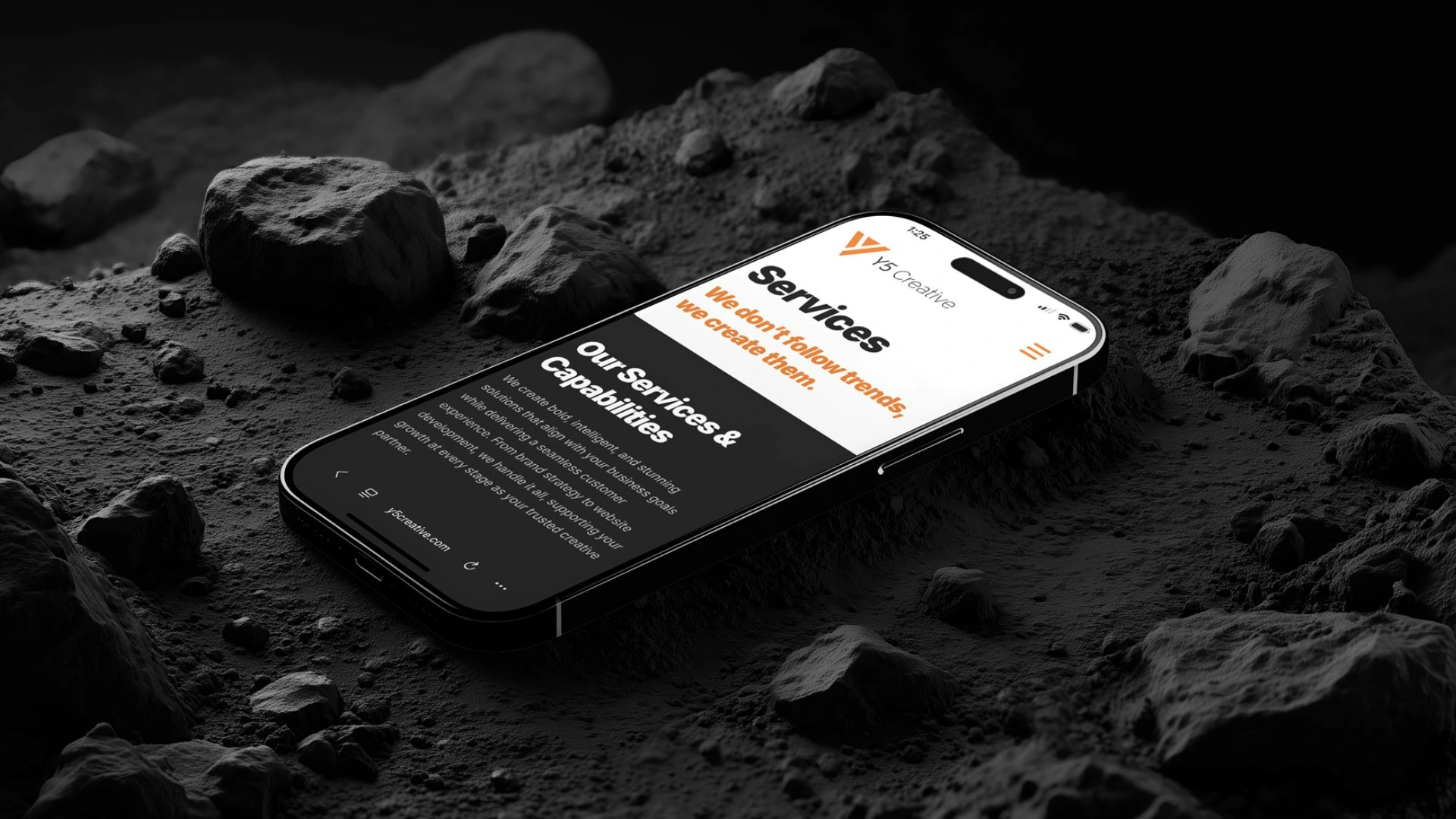 Y5 Creative services page on a phone resting on rocks